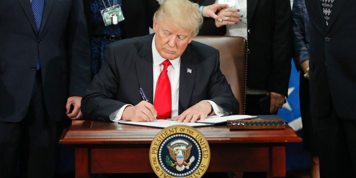 U.S. president signing an immigration-related executive order during a public event