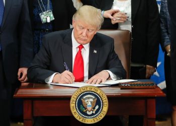U.S. president signing an immigration-related executive order during a public event