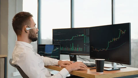 Professional cryptocurrency trader monitoring multiple screens