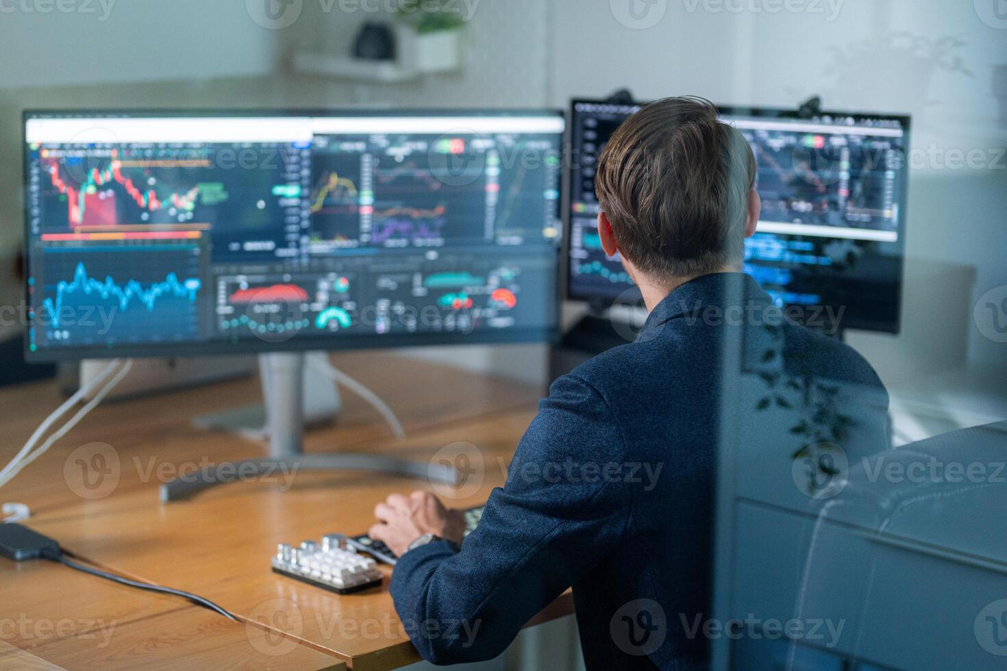Trader analyzing stock charts on multiple screens