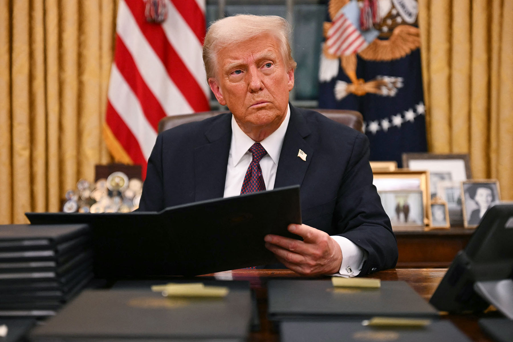 President Trump signing an executive order in the White House, related to 2025 immigration policies