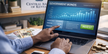 Kenyan investor at a desk using a laptop to invest in government bonds with Kenyan shillings and charts in landscape view