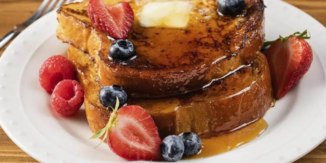 Golden French toast stack with butter, maple syrup and fresh berries