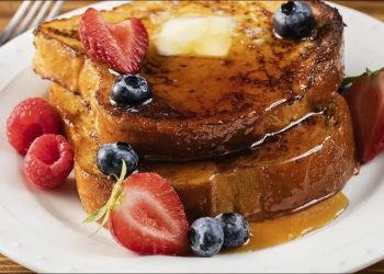 Golden French toast stack with butter, maple syrup and fresh berries