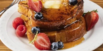 Golden French toast stack with butter, maple syrup and fresh berries
