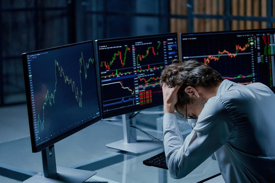 investing frustrated sitting Infront of his workstation