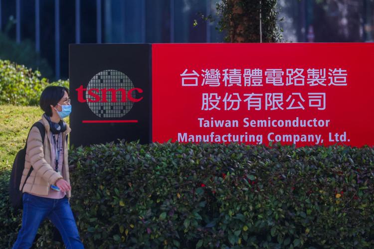 Person walking past TSMC headquarters sign in Taiwan