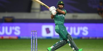 Fakhar Zaman of Pakistan batting in a cricket match, playing a powerful shot with stumps visible behind him on a stadium field.
