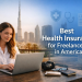 Freelancer woman working on a laptop with Dubai skyline background illustrating best health insurance options for freelancers in America