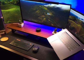 Modern home office setup with laptop and ultra‑wide monitors on a wooden desk for making money online from home