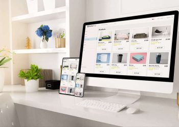 Modern home office desk with computer, tablet and smartphone showing an online store with small business products.