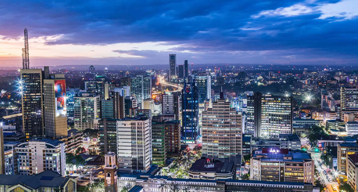 Vibrant modern city skyline at dusk with illuminated skyscrapers representing opportunity and success for Africans relocating abroad in 2026