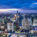 Vibrant modern city skyline at dusk with illuminated skyscrapers representing opportunity and success for Africans relocating abroad in 2026