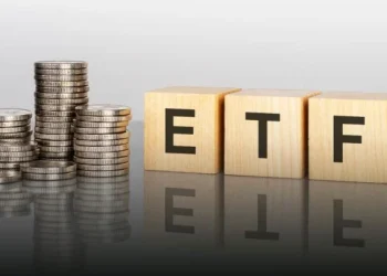 ETF investment concept with stacked coins representing high-yield passive income investments in 2026