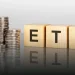 ETF investment concept with stacked coins representing high-yield passive income investments in 2026