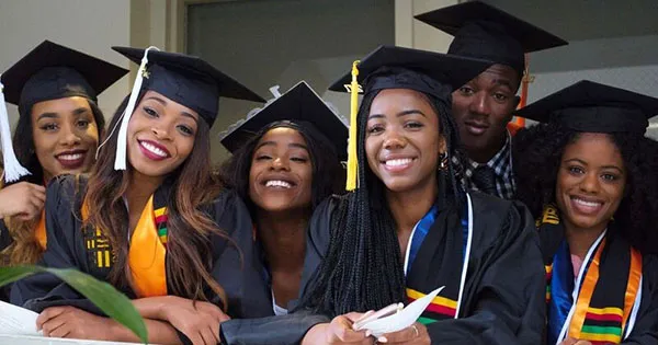 alt="Happy African graduates in caps and gowns celebrating scholarship success and academic achievement"