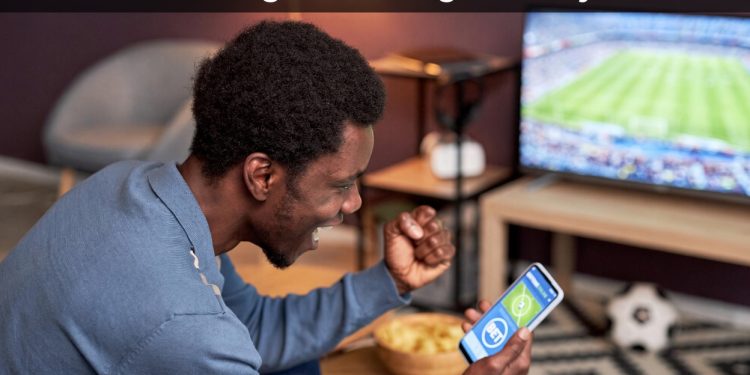 Young Kenyan man excited while betting on phone vs saving concept