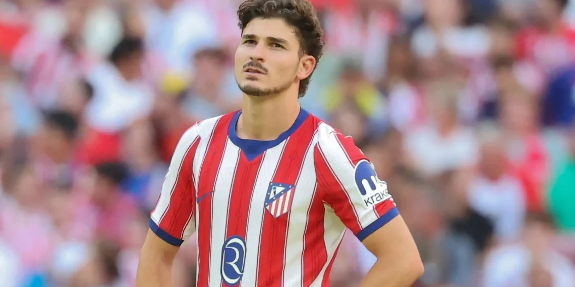 Julián Álvarez of Atlético Madrid looking upward in his red and white striped jersey with the text overlay “Julián Álvarez Remains at Atlético.”