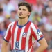 Julián Álvarez of Atlético Madrid looking upward in his red and white striped jersey with the text overlay “Julián Álvarez Remains at Atlético.”